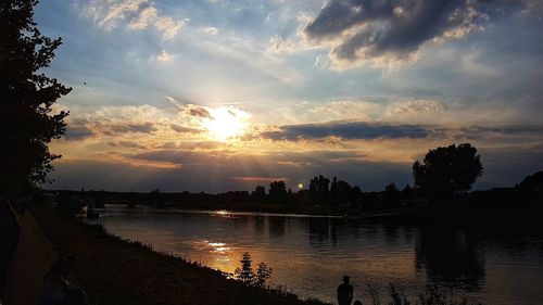 Scenic view of river against sky at sunset