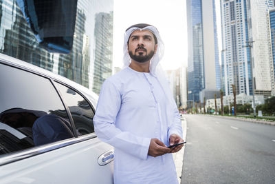 Young man using mobile phone in city