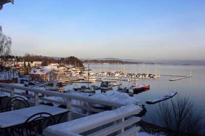 Boats moored at harbor against clear sky