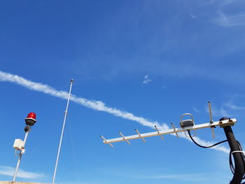 Low angle view of antenna against blue sky