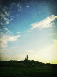 Scenic view of grassy field against cloudy sky