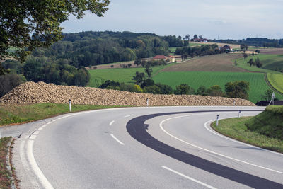 Road by landscape against sky