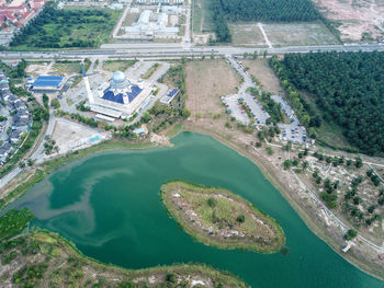 Drone view abdullah fahim mosque with green lake beside.