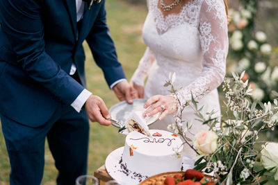 Midsection of bride holding bouquet