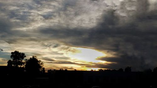 Silhouette of city against dramatic sky