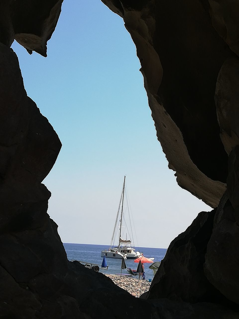 SAILBOAT ON BEACH AGAINST CLEAR SKY