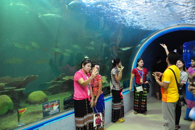 People in fish tank at aquarium