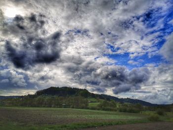 Scenic view of field against cloudy sky