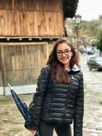 Young woman wearing jacket standing outdoors