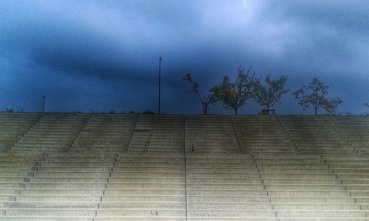 sky, cloud - sky, cloudy, low angle view, building exterior, built structure, architecture, cloud, tree, weather, overcast, street light, outdoors, day, no people, nature, dusk, building, storm cloud, growth