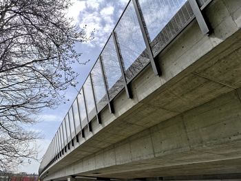 Low angle view of bridge amidst buildings against sky