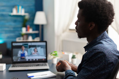 Side view of businessman talking on video conference