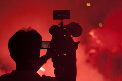 Rear view of silhouette people photographing