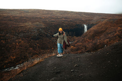 Full length rear view of man standing on rock