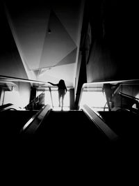 Silhouette of person standing on staircase in building