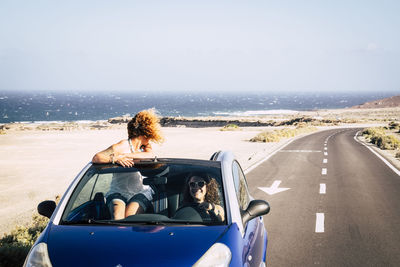 Portrait of woman on road against sky