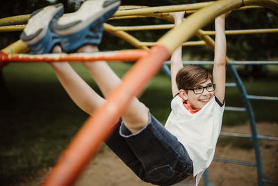 Hanging around at climbing frame on playground looking happily to side and enjoy life