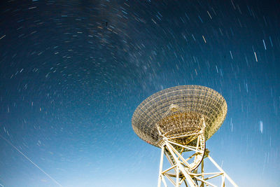 Low angle view of communications tower against sky at night