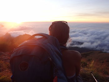 Rear view of female hiker sitting on mountain