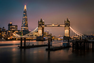 View of suspension bridge in city at night