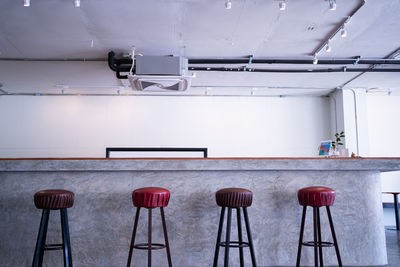 Empty chairs and table against wall