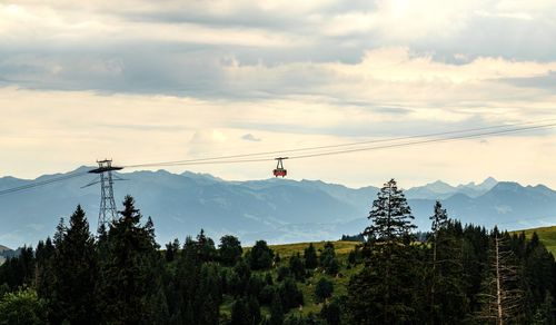 Low angle view of overhead cable car against sky