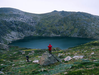 Man standing on rock by lake