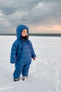 Portrait of girl standing on snow covered landscape