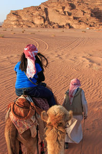 Woman riding on camel at desert