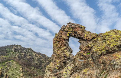 Low angle view of rock formation against sky