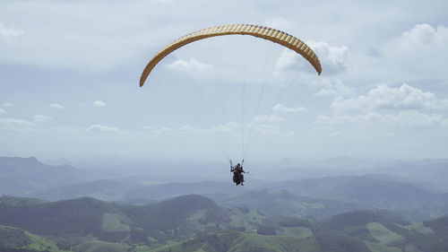 Person paragliding against sky