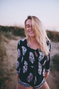 Smiling young woman standing on field