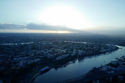 High angle view of city by river against sky