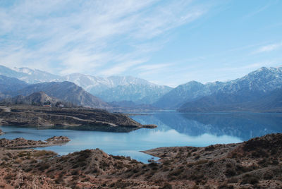 Scenic view of lake by mountains against sky