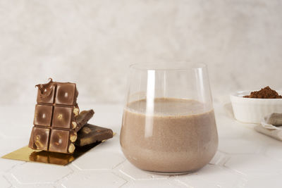 Delicious homemade cocoa drink with cocoa powder and pieces of chocolate bar.