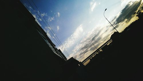 Low angle view of silhouette building against blue sky