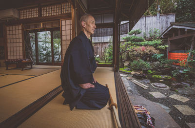 Full length of man sitting in building