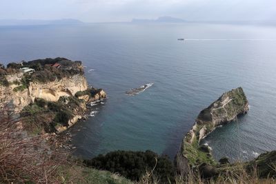 High angle view of rocks by sea against sky