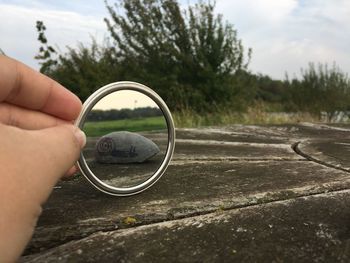 Stone reflecting in mirror held by person