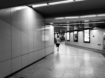 Rear view of man walking in subway