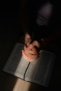 High angle view of woman praying in darkroom