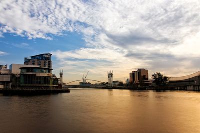 River by buildings against sky in city