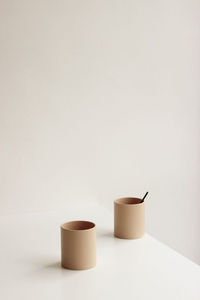 Close-up of empty coffee cup on table against white background