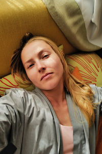 Portrait of young woman sitting on sofa at home