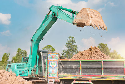 Bulldozer on land against sky