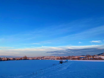 Scenic view of snowcapped landscape against blue sky