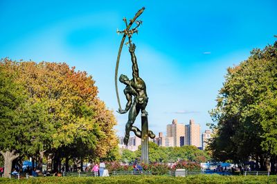 Statue in park with city in background