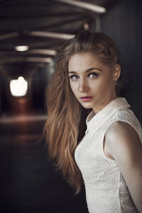 Portrait of young woman against black background