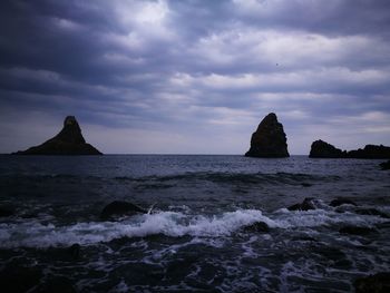 Scenic view of rocks in sea against sky