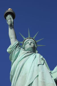 Low angle view of statue against blue sky